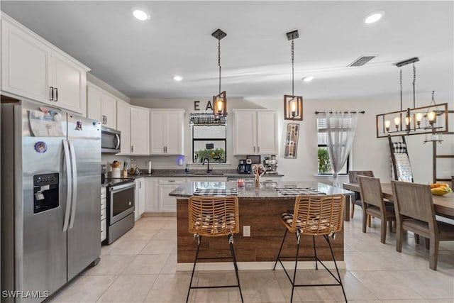 17152 Ashford Ter, Fort Myers, FL 33967 - kitchen featuring stainless steel appliances, a sink, a chandelier, white cabinetry, and light tile patterned floors
