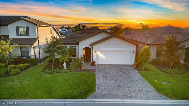 17152 Ashford Ter, Fort Myers, FL 33967 - view of front facade with decorative driveway, an attached garage, a tiled roof, and a lawn