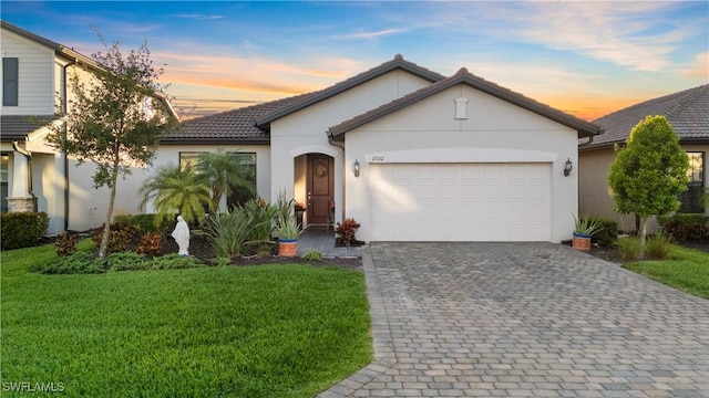 17152 Ashford Ter, Fort Myers, FL 33967 - view of front of home with decorative driveway, stucco siding, a garage, and a yard