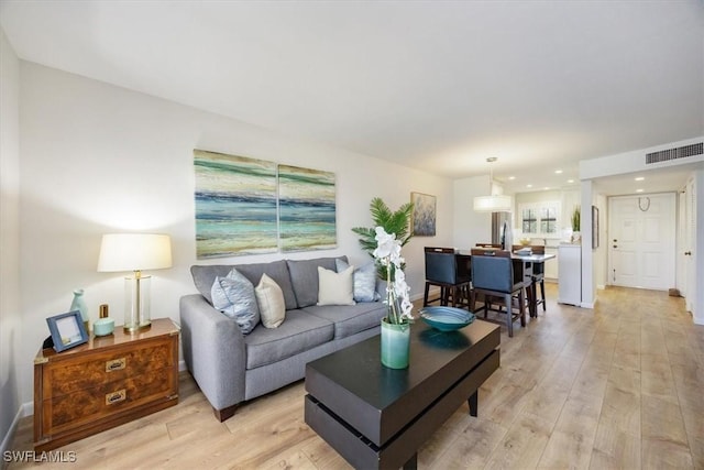 living area featuring recessed lighting, visible vents, baseboards, and light wood-style floors