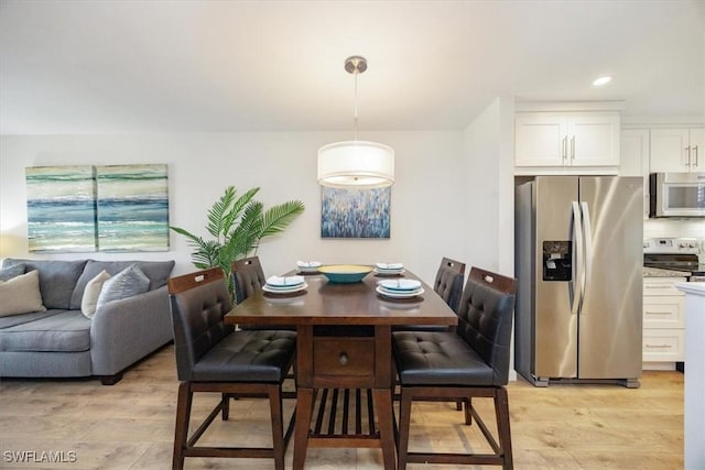 dining room with recessed lighting and light wood-style floors