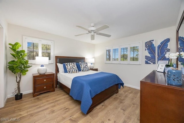 bedroom with light wood-type flooring, baseboards, and multiple windows