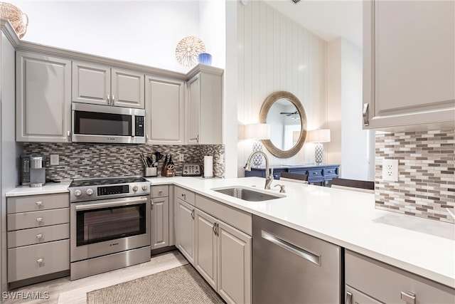 831 Sailaway Ln Unit 203, Naples, FL 34108 - kitchen featuring appliances with stainless steel finishes, gray cabinetry, a sink, and light countertops
