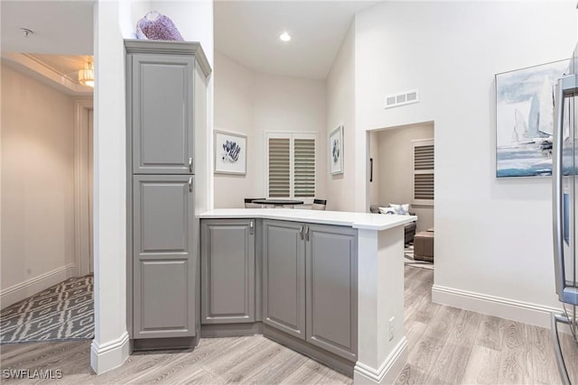 831 Sailaway Ln Unit 203, Naples, FL 34108 - kitchen with gray cabinets, a peninsula, light wood-type flooring, and recessed lighting