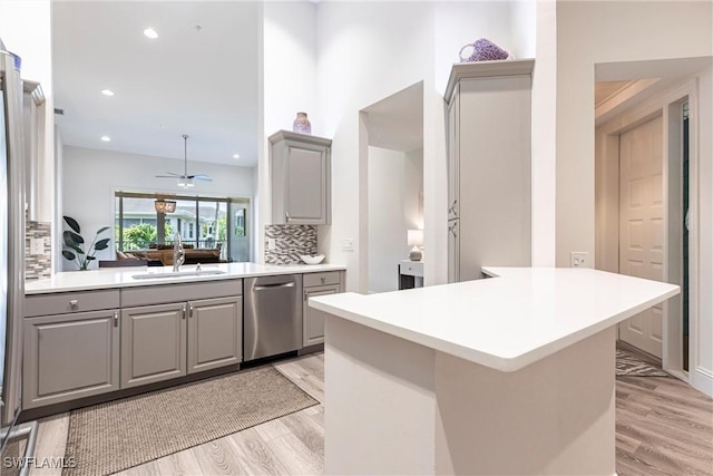 831 Sailaway Ln Unit 203, Naples, FL 34108 - kitchen with gray cabinetry, dishwasher, a sink, decorative backsplash, and light wood finished floors