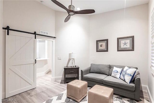 831 Sailaway Ln Unit 203, Naples, FL 34108 - living room with light wood-style floors, a ceiling fan, a barn door, and baseboards