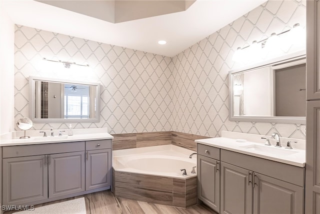 831 Sailaway Ln Unit 203, Naples, FL 34108 - full bath with two vanities, a garden tub, wood finished floors, and recessed lighting