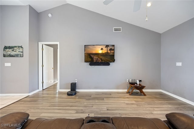 living area featuring wood finished floors, baseboards, visible vents, a ceiling fan, and high vaulted ceiling