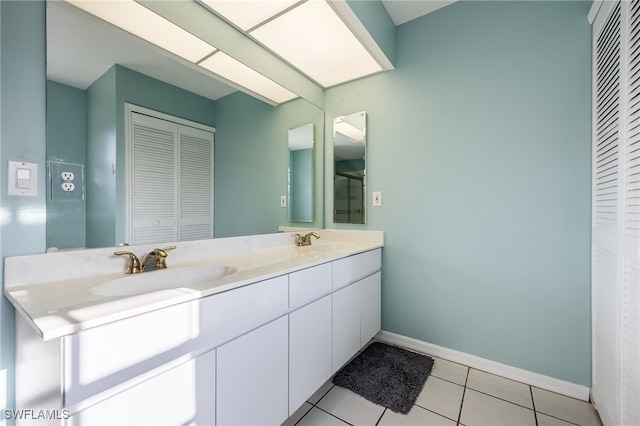 full bathroom with double vanity, a closet, tile patterned flooring, and a sink