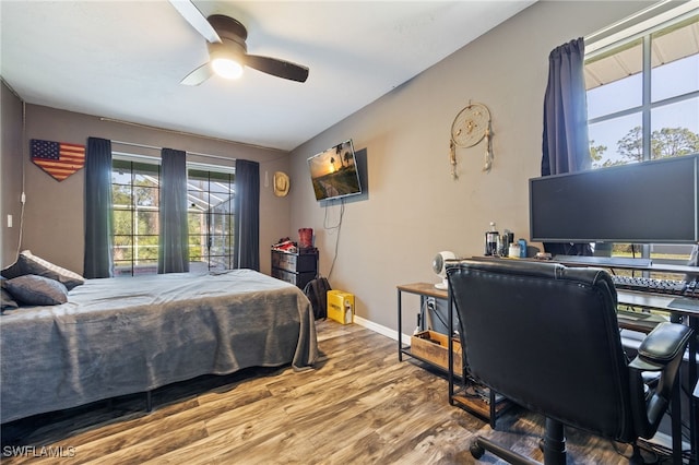 bedroom featuring wood finished floors, ceiling fan, and baseboards