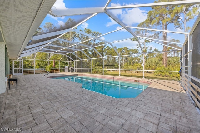 outdoor pool with glass enclosure and a patio area