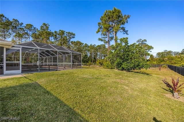 view of yard featuring glass enclosure and fence