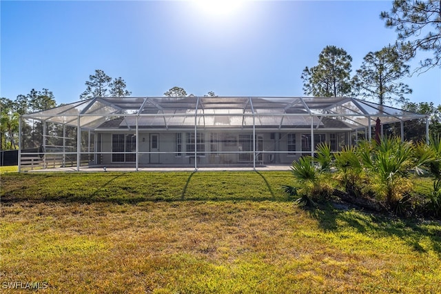 rear view of property featuring a yard and a lanai