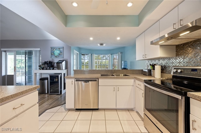 kitchen featuring a sink, white cabinets, appliances with stainless steel finishes, and under cabinet range hood