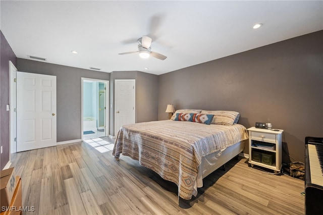 bedroom featuring visible vents, ensuite bathroom, a ceiling fan, and light wood-style flooring