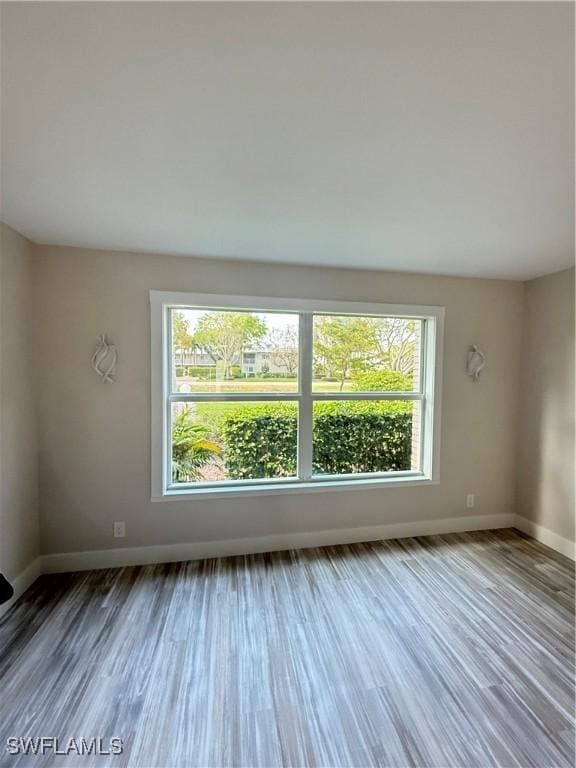 530 Broad Ave S Unit 530, Naples, FL 34102 - empty room featuring wood finished floors, plenty of natural light, and baseboards