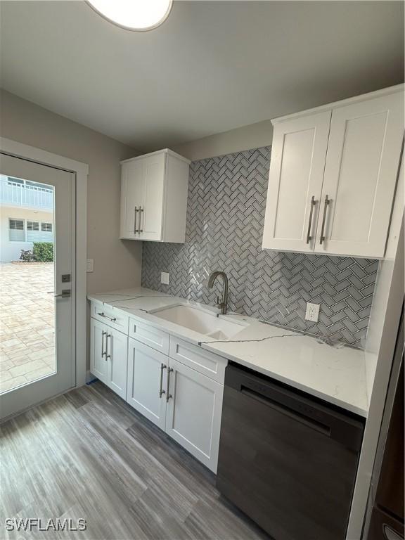 530 Broad Ave S Unit 530, Naples, FL 34102 - kitchen featuring a sink, dishwashing machine, white cabinetry, and decorative backsplash