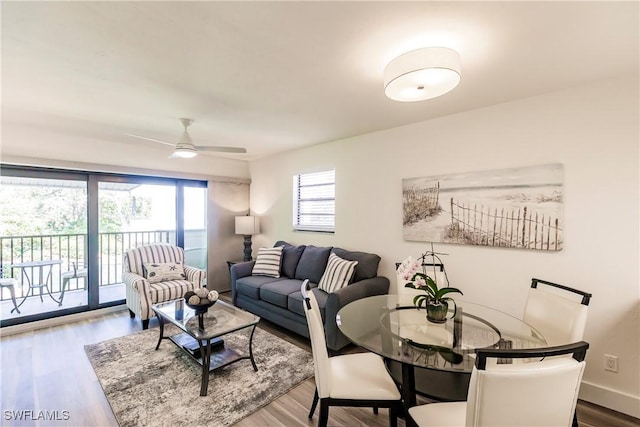 living room featuring wood finished floors, ceiling fan, and baseboards