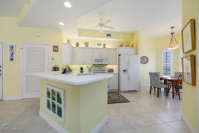 kitchen with white appliances, a ceiling fan, a peninsula, light countertops, and hanging light fixtures