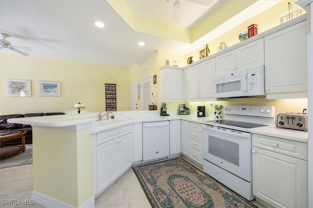 kitchen with white appliances, a sink, a ceiling fan, a peninsula, and open floor plan
