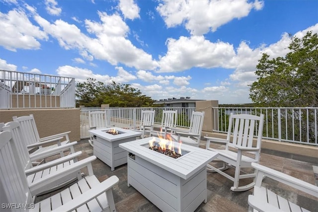 wooden terrace featuring a patio and a fire pit