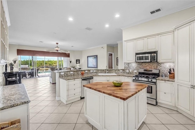 8442 Mallards Way, Naples, FL 34114 - kitchen with visible vents, a peninsula, butcher block counters, a sink, and stainless steel appliances