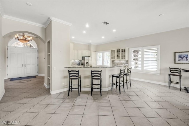 8442 Mallards Way, Naples, FL 34114 - kitchen featuring an inviting chandelier, stainless steel fridge, a breakfast bar, light tile patterned floors, and visible vents