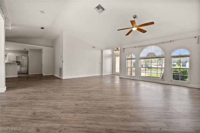 unfurnished living room featuring visible vents, a ceiling fan, lofted ceiling, and wood finished floors