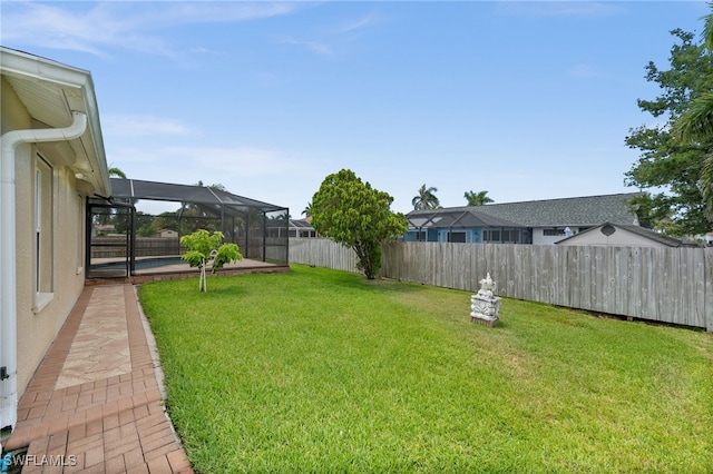 view of yard with a lanai, a fenced backyard, and an outdoor pool