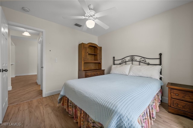 bedroom featuring a ceiling fan, baseboards, visible vents, and light wood finished floors