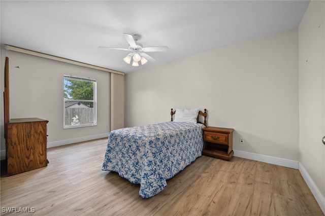 bedroom with baseboards, ceiling fan, and wood finished floors
