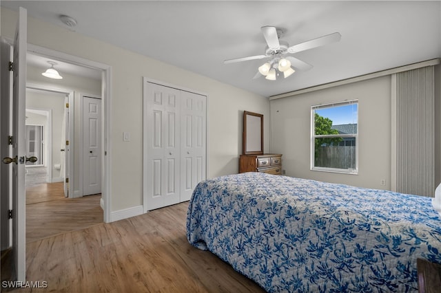 bedroom with baseboards, ceiling fan, wood finished floors, and a closet