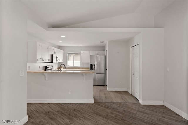 kitchen featuring a sink, appliances with stainless steel finishes, a peninsula, and wood finished floors