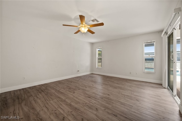 unfurnished room with a ceiling fan, baseboards, visible vents, and wood finished floors