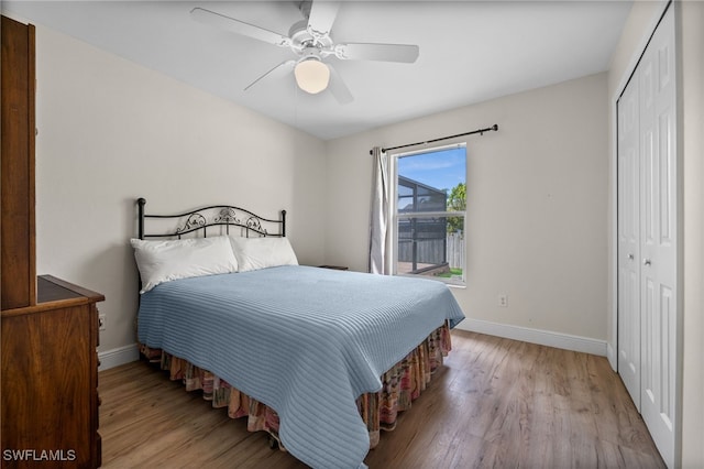 bedroom with baseboards, ceiling fan, a closet, and wood finished floors