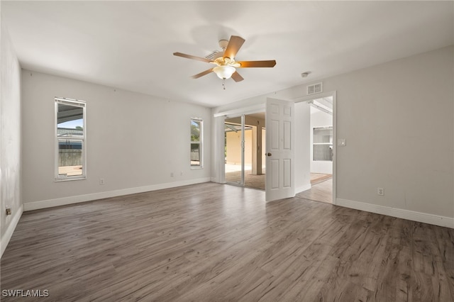 empty room featuring baseboards, ceiling fan, and wood finished floors