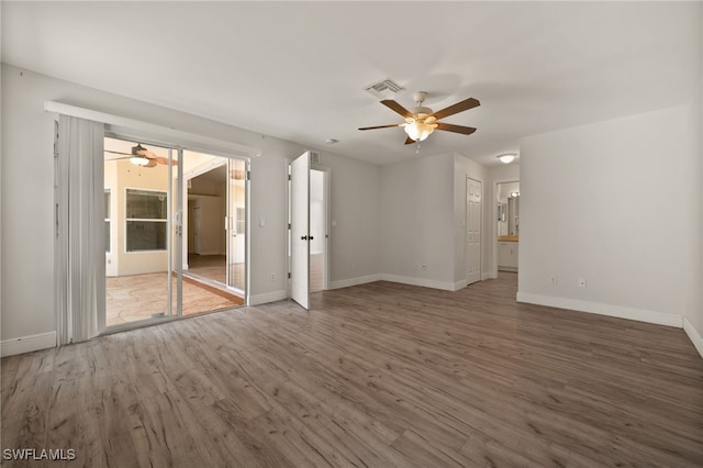 unfurnished living room featuring visible vents, baseboards, ceiling fan, and wood finished floors