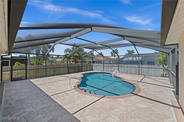 view of pool with a fenced in pool, glass enclosure, a patio area, and fence