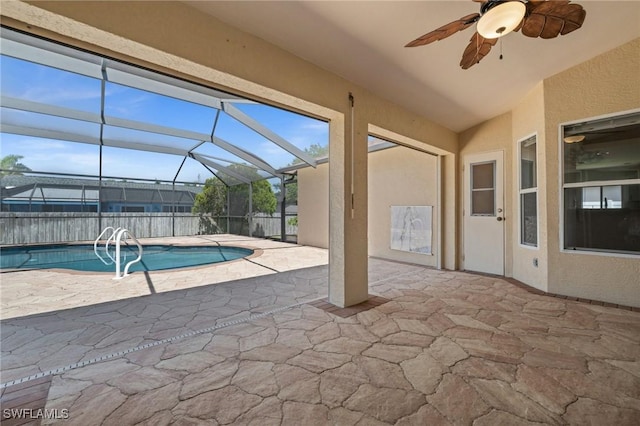 view of swimming pool featuring ceiling fan, fence, a fenced in pool, a patio area, and glass enclosure