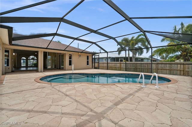 view of swimming pool with a patio, a lanai, a fenced in pool, and fence