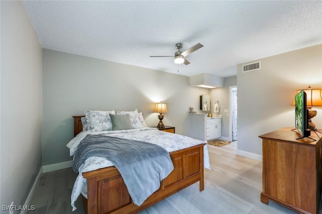 15177 Parkside Dr Unit 104, Fort Myers, FL 33908 - bedroom with connected bathroom, light wood-style floors, ceiling fan, visible vents, and baseboards