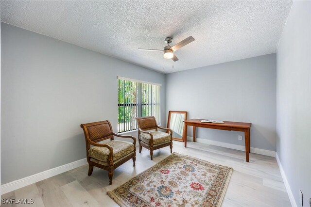 15177 Parkside Dr Unit 104, Fort Myers, FL 33908 - living area featuring light wood finished floors, a ceiling fan, a textured ceiling, and baseboards