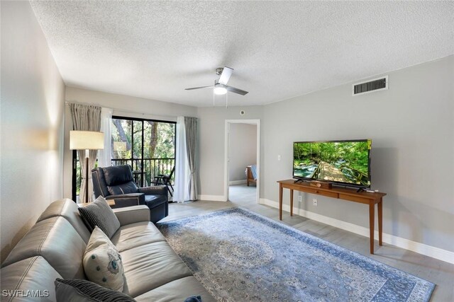 15177 Parkside Dr Unit 104, Fort Myers, FL 33908 - living room featuring a ceiling fan, visible vents, a textured ceiling, and baseboards