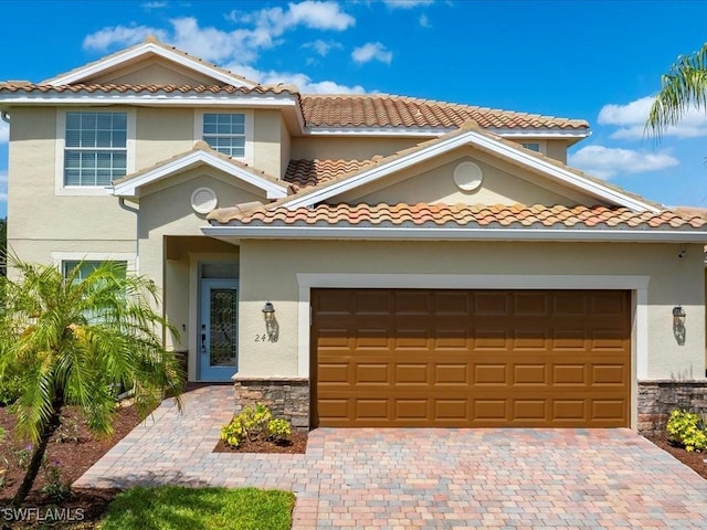 2478 Heydon Cir E, Naples, FL 34120 - view of front of house with an attached garage, stucco siding, a tiled roof, and stone siding