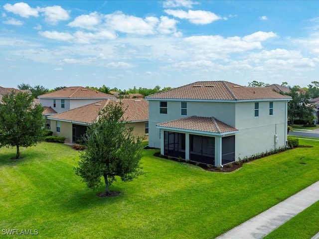 2478 Heydon Cir E, Naples, FL 34120 - rear view of property featuring a sunroom, a yard, stucco siding, and a tiled roof