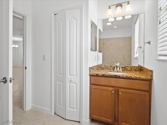 2478 Heydon Cir E, Naples, FL 34120 - bathroom featuring an inviting chandelier, vanity, a closet, baseboards, and tile patterned flooring