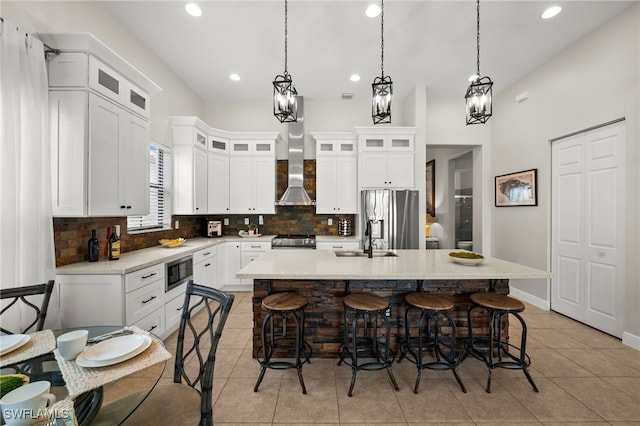 kitchen with a kitchen bar, backsplash, appliances with stainless steel finishes, and a sink