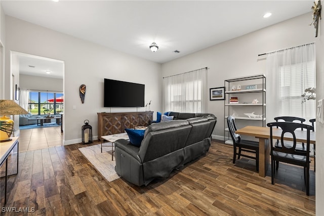 living room featuring baseboards, wood finished floors, and recessed lighting