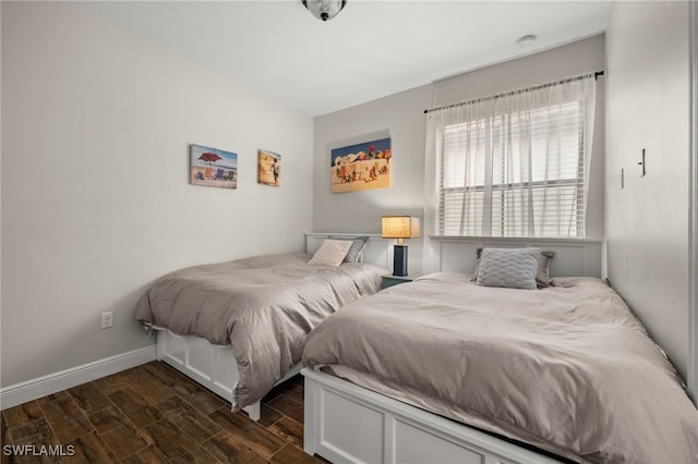 bedroom with baseboards and dark wood finished floors