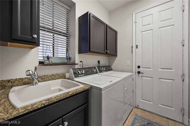laundry area with washer and dryer, cabinet space, a sink, and light tile patterned floors